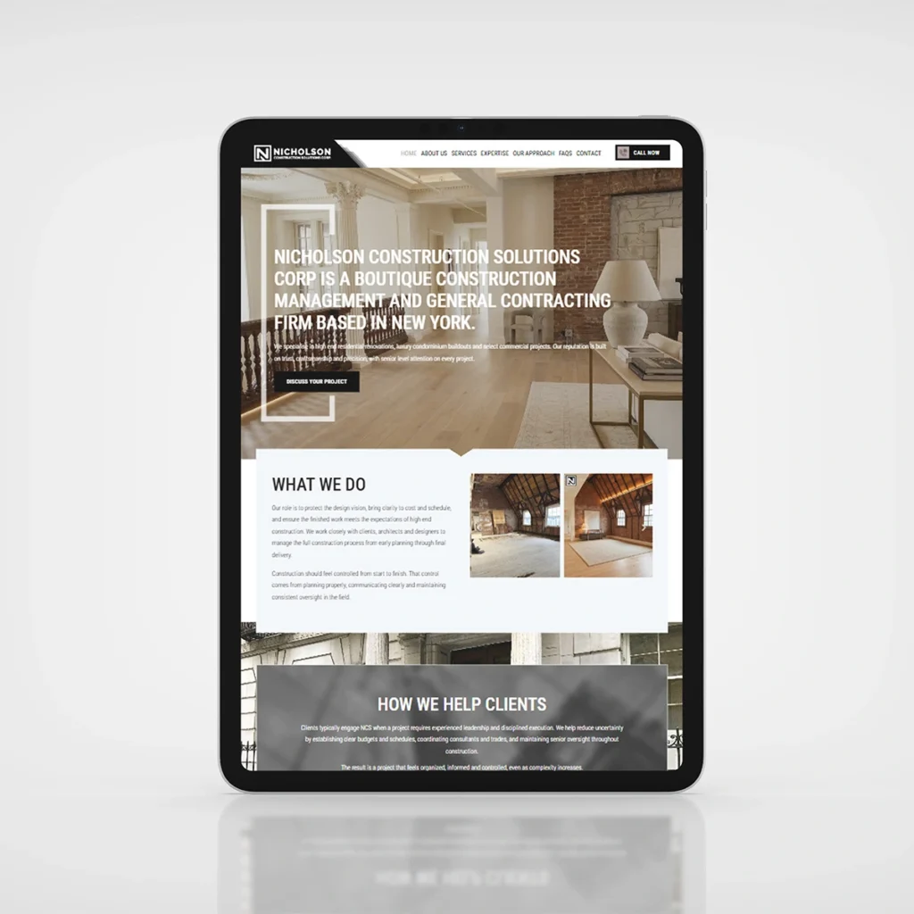 Tablet screen showing a construction company homepage over a living-room photo with a bold white headline